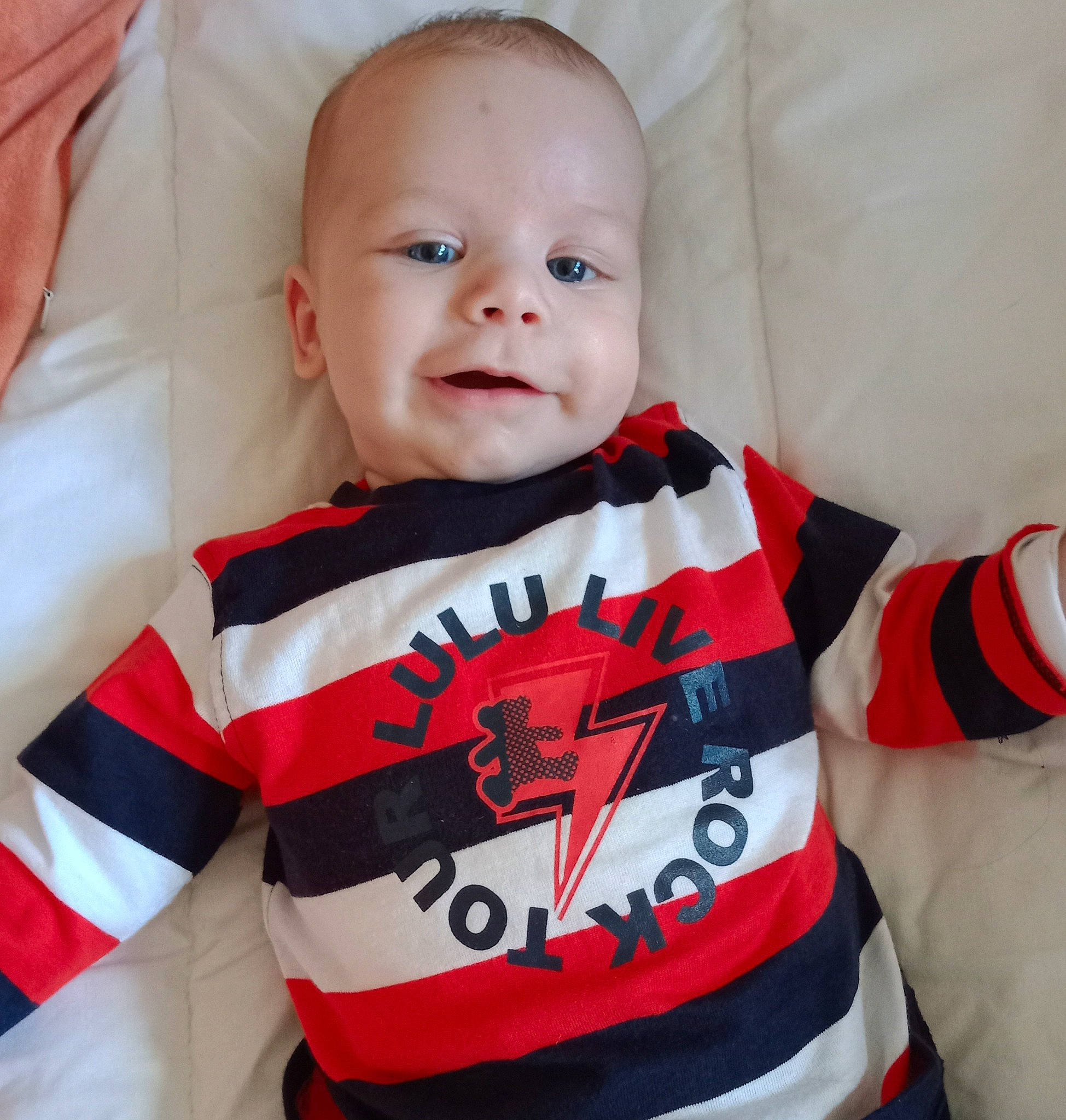 Malone participe au concours pour gagner de l'argent avec cette photo : arm, baby, baby_toddler_clothing, cheek, clothing, eye, eyebrow, facial_expression, hair, human_body, lip, mouth, neck, nose, orange, outerwear, person, sleeve, smile, t_shirt