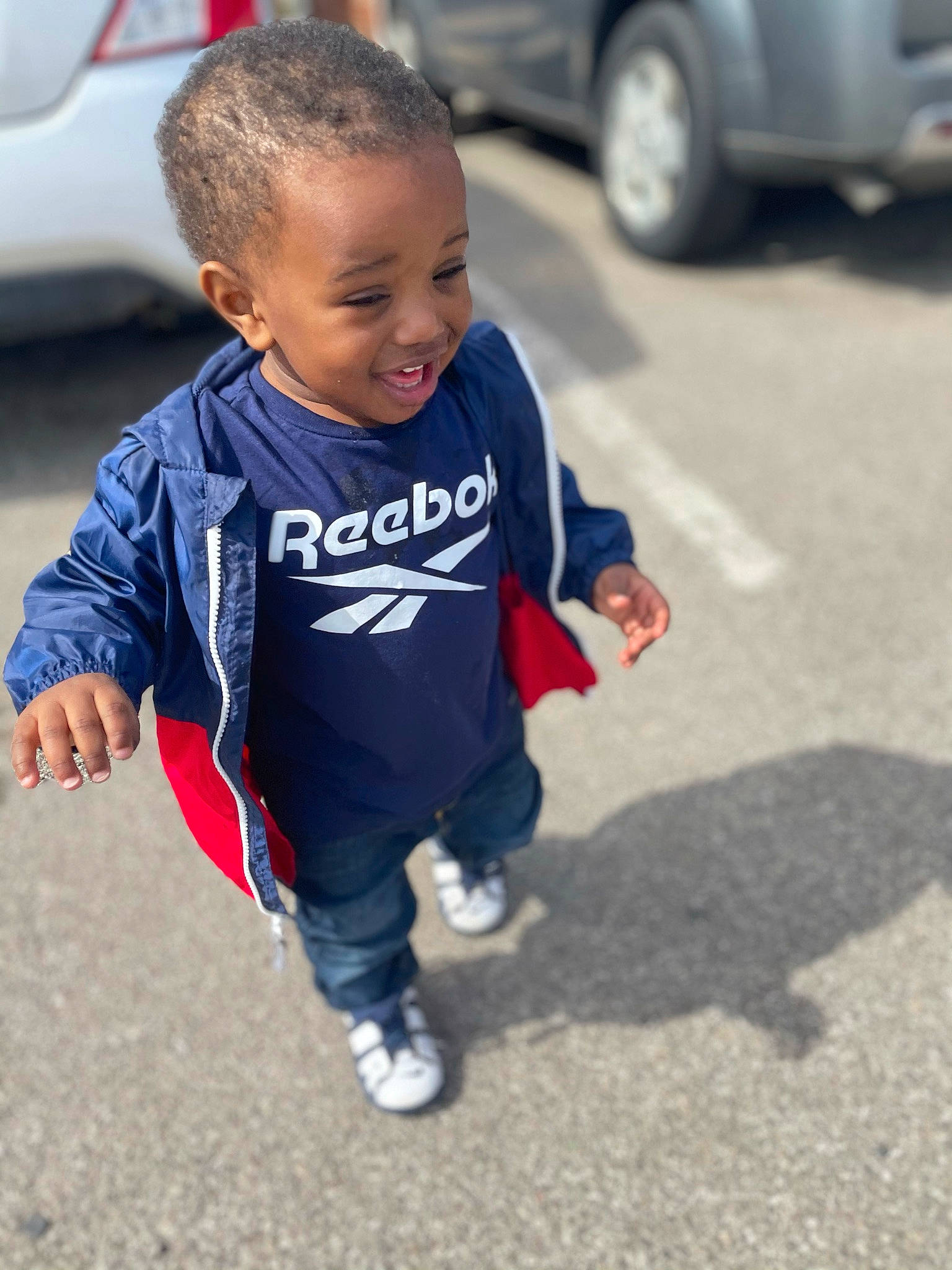 Dewayne is registered to the contest to win money with this photo: asphalt, automotive_design, automotive_exterior, automotive_tire, car, electric_blue, face, happy, joy, motor_vehicle, parking, person, personal_luxury_car, road, smile, snapshot, t_shirt, tire, toddler, vehicle_door