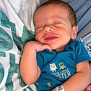 Caysen joined the competition — help win amazing prizes! baby, newborn, smile, onesie, blue_clothing, infant, person, hand, hospital_wristband, sleepy, cute, child, holding, closeup, face, skin, human, parent, happy, resting