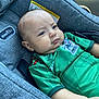 baby, child, car_seat, green_shirt, mexico_jersey, infant, cute, pout, serious_expression, clothing, seatbelt, car_interior, portrait, person, young_child, indoors, closeup, head_and_shoulders, fabric, casual