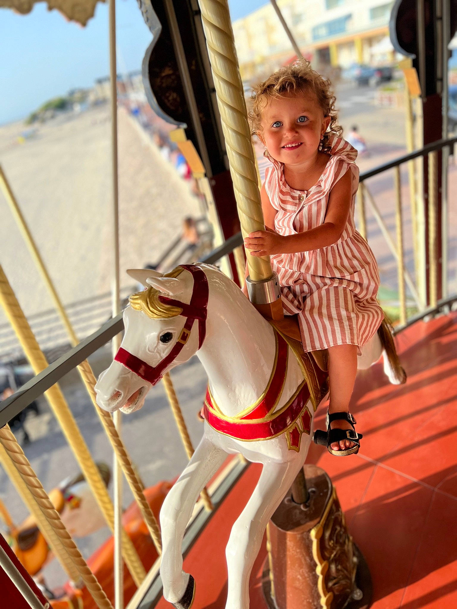 Elyana participe au concours pour gagner de l'argent avec cette photo : blond, bridle, carousel, dress, event, fun, happy, horse, horse_supplies, horse_tack, joy, leisure, person, playground, recreation, rein, saddle, sky, smile, summer