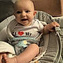 baby, infant, smiling, child, white_shirt, heart_graphic, baby_seat, cushion, indoor, carpet, happy, cute, chubby_legs, hand, foot, face, person, young_child, comfortable, seat