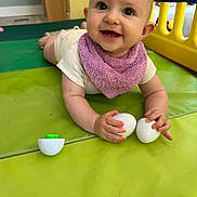 Inaya participe au concours pour gagner de l'argent avec cette photo : baby, child, play_mat, purple_bib, white_eggs, indoor, smiling, playpen, toy, person, crawling, floor, cute, infant, happy, young_child, colorful, plastic, hand, head
