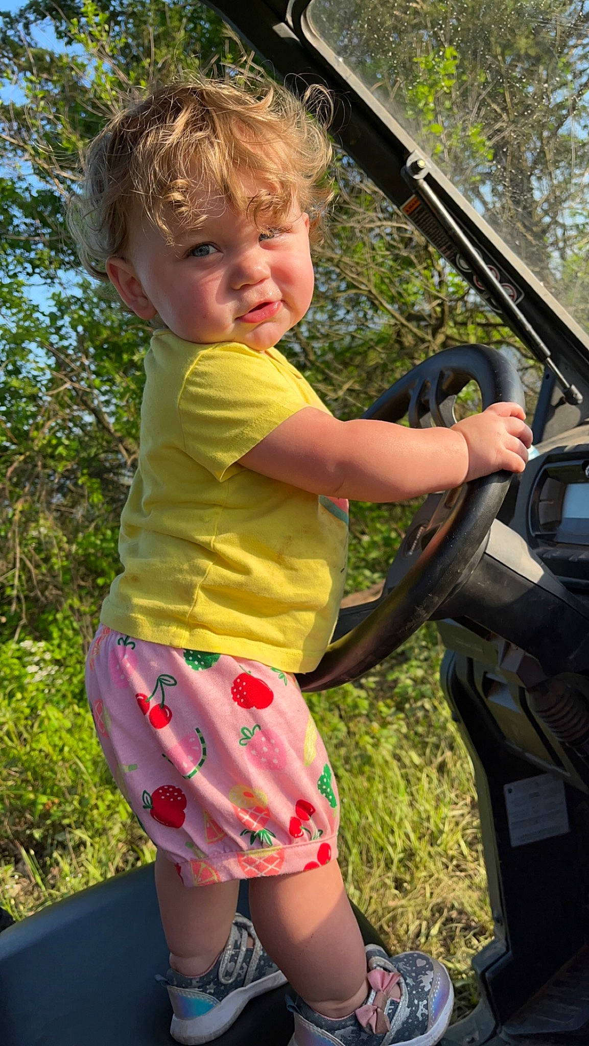 Harper joined the competition — help win amazing prizes! automotive_exterior, blond, bumper, family_car, fun, grass, happy, human_leg, leisure, motor_vehicle, people_in_nature, person, pink, plant, recreation, shorts, summer, t_shirt, toddler, tree