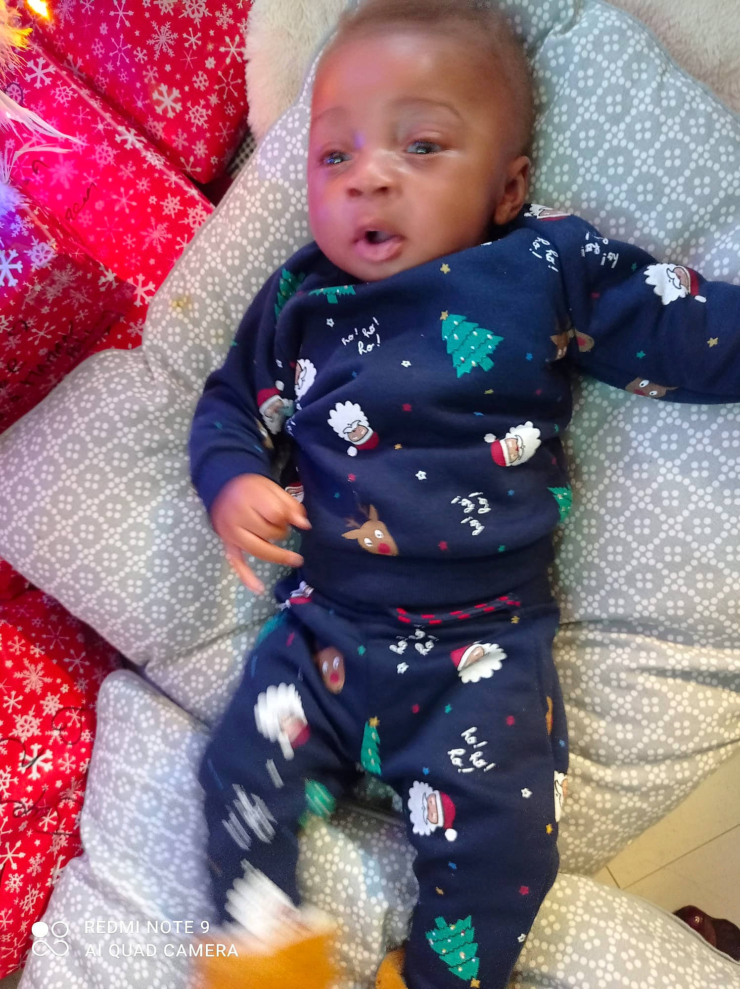 Kyllian Calvin-junior participe au concours pour gagner de l'argent avec cette photo : baby, baby_toddler_clothing, carmine, child, comfort, face, fun, happy, head, holiday, lap, linens, pajamas, pattern, person, play, red, sitting, sleeve, sock