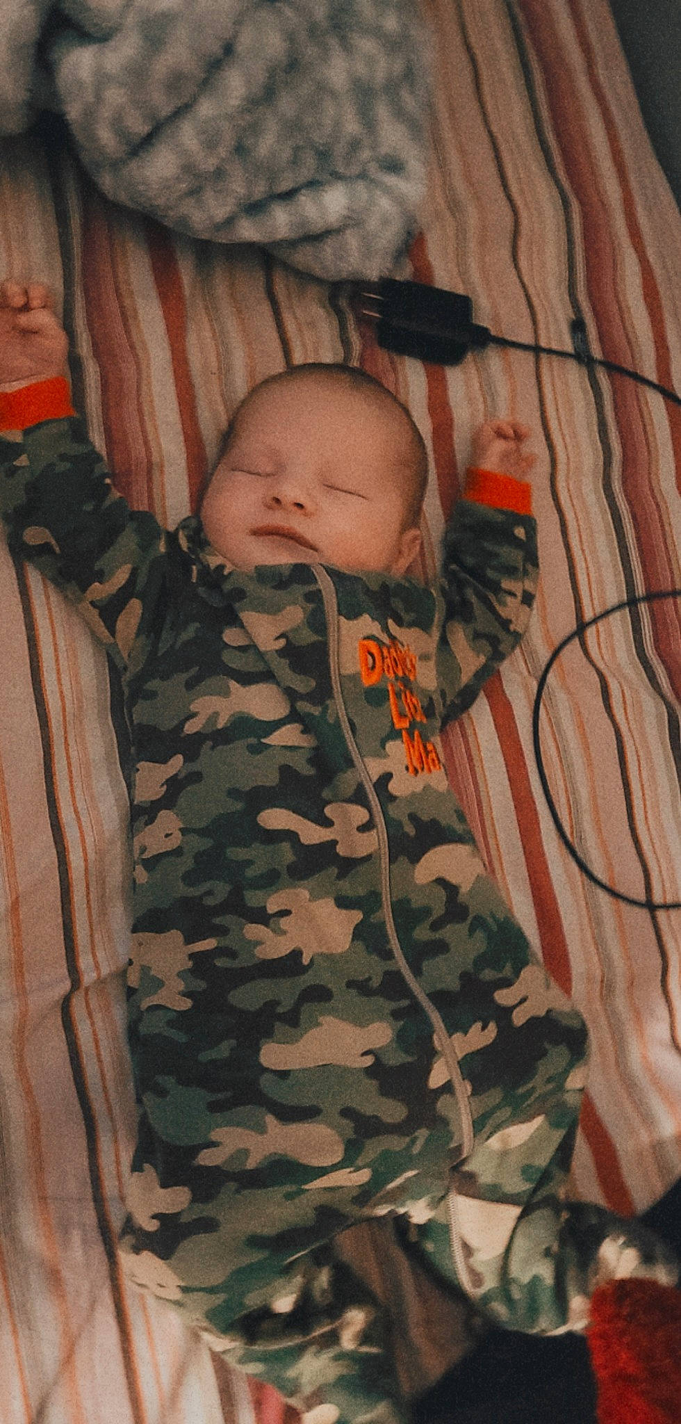 Elisha is registered to the contest to win money with this photo: baby, baby_products, baby_toddler_clothing, camouflage, cheek, child, comfort, head, human_body, linens, mammal, military_camouflage, military_uniform, pattern, person, skin, sleeve, textile, toddler, uniform