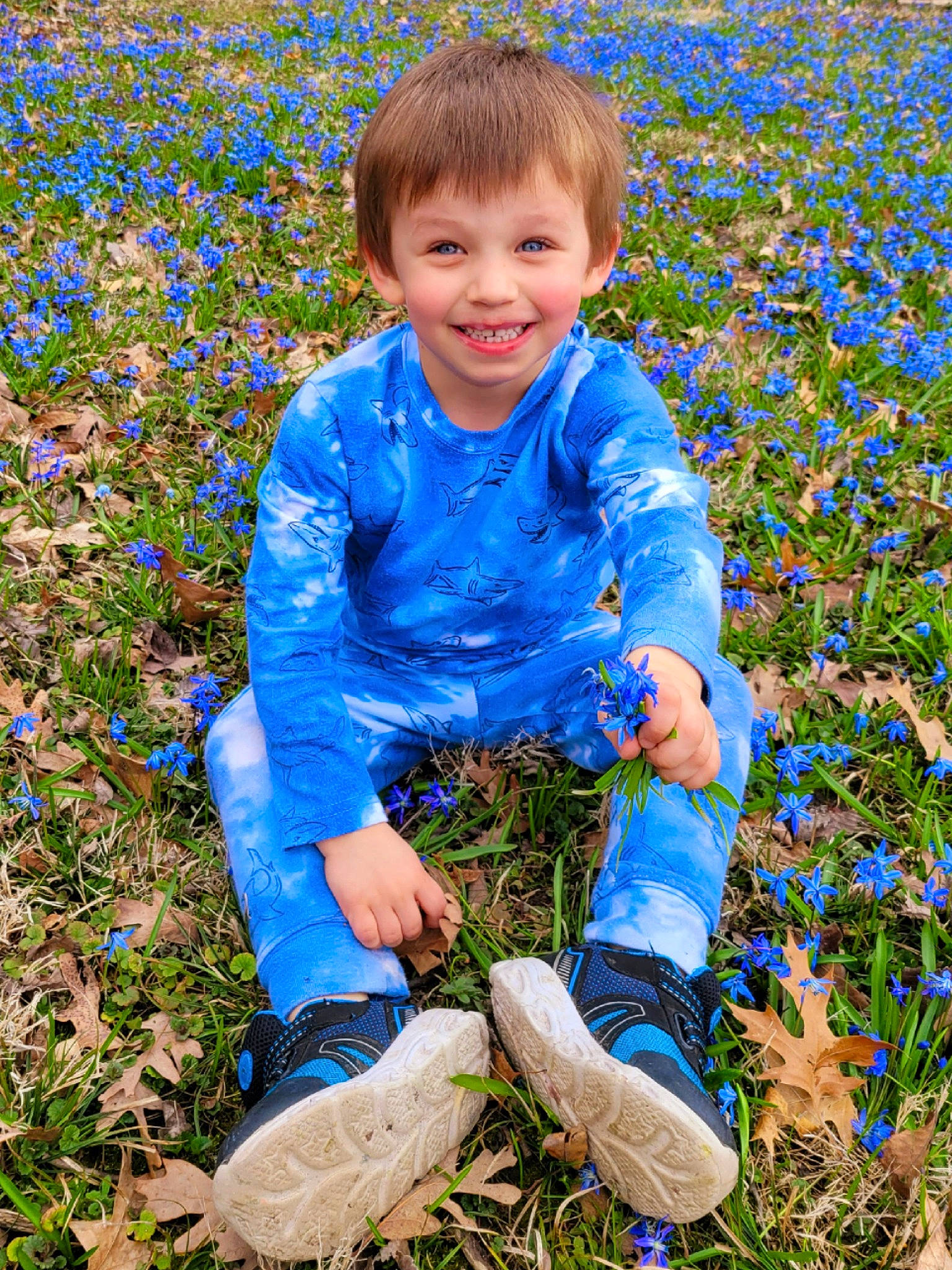 Hunter is registered to the contest to win money with this photo: baby_toddler_clothing, boot, child, electric_blue, footwear, grass, grassland, happy, human_leg, joy, meadow, people_in_nature, person, plant, prairie, shoe, smile, sneakers, soil, standing