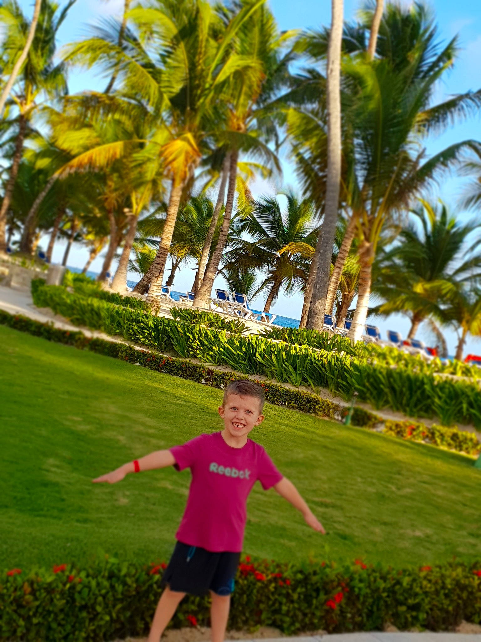 Soan a rejoint le concours — aidez-le/la à gagner de superbes lots ! arecales, beach, botany, child, fun, grass, happy, joy, leisure, palm_tree, person, plant, sea, sky, smile, summer, sunlight, tourism, tree, tropics
