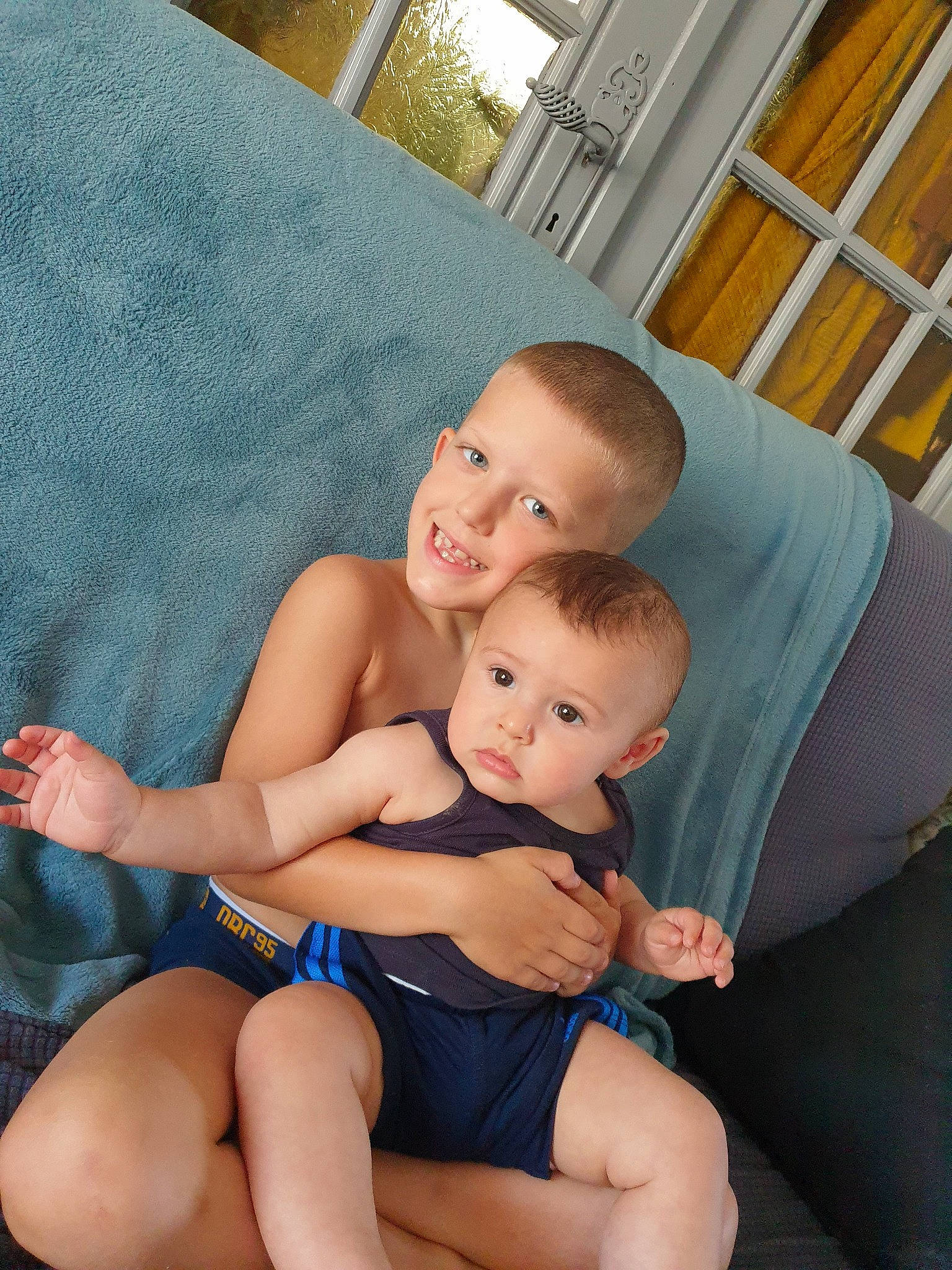 Adonis a rejoint le concours — aidez-le/la à gagner de superbes lots ! abdomen, baby, barefoot, black_hair, child, finger, joy, lap, leg, muscle, neck, person, sitting, skin, smile, sole, thigh, toddler, trunk, vacation