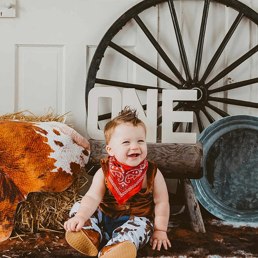 Waylon joined the competition — help win amazing prizes! baby, clothing, dress, face, footwear, happy, head, machine, outdoors, pants, person, photography, portrait, shoe, sitting, spoke, transportation, vehicle, wheel, wood