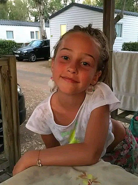 Tiana participe au concours pour gagner de l'argent avec cette photo : car, chair, child, dress, event, fun, grass, hairstyle, happy, jewellery, joy, leisure, person, plant, sitting, smile, t_shirt, tire, toddler, tree