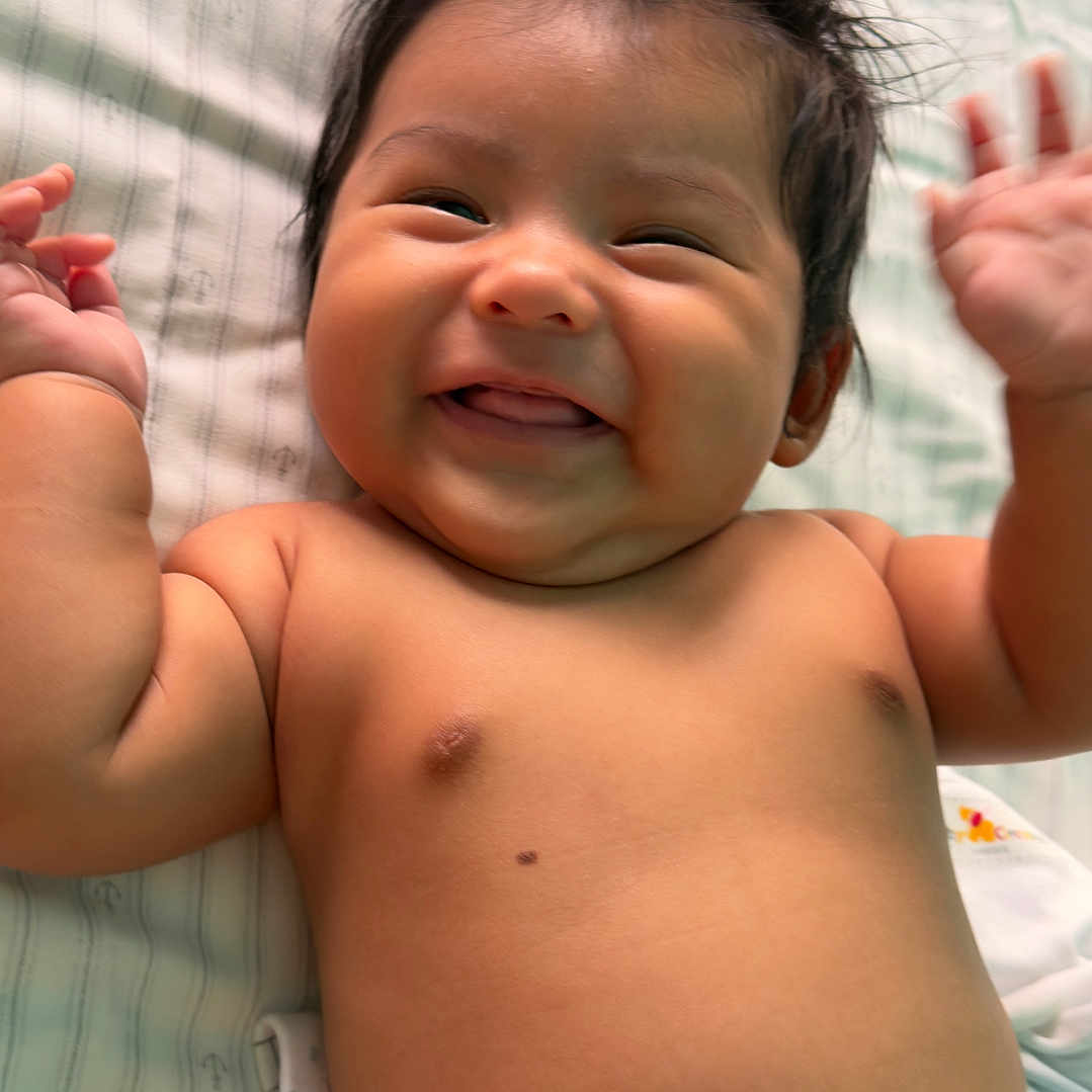 J. Ruben joined the competition — help win amazing prizes! baby, newborn, infant, child, smiling, happy, lying_down, portrait, face, eyes, hair, arms, hands, diaper, blanket, bed, indoor, close_up, adorable, photography