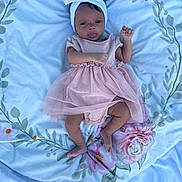 Kaylyn joined the competition — help win amazing prizes! baby, infant, child, pink_dress, headband, blanket, floral_pattern, soft_texture, lying_down, curious_expression, indoors, small_hands, small_feet, cute, adorable, portrait, one_person, young, toddler, fabric