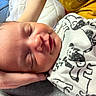 baby, newborn, sleeping, hand, blanket, animal_print, yellow_shirt, closeup, indoor, comfort, peaceful, face, skin, person, caring, rest, infant, portrait, cozy, tender