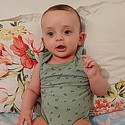 Amar participe au concours pour gagner de l'argent avec cette photo : baby, bed, child, curious, cute, expression, face, feet, floral_pattern, green_clothing, hands, head, indoors, infant, legs, onesie, pillow, sitting, skin, young_child