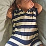 baby, sleeping, infant, onesie, striped_clothing, bed, pillow, blanket, sleep, peaceful, rest, child, skin, head, arms, legs, indoors, cozy, comfort, cute