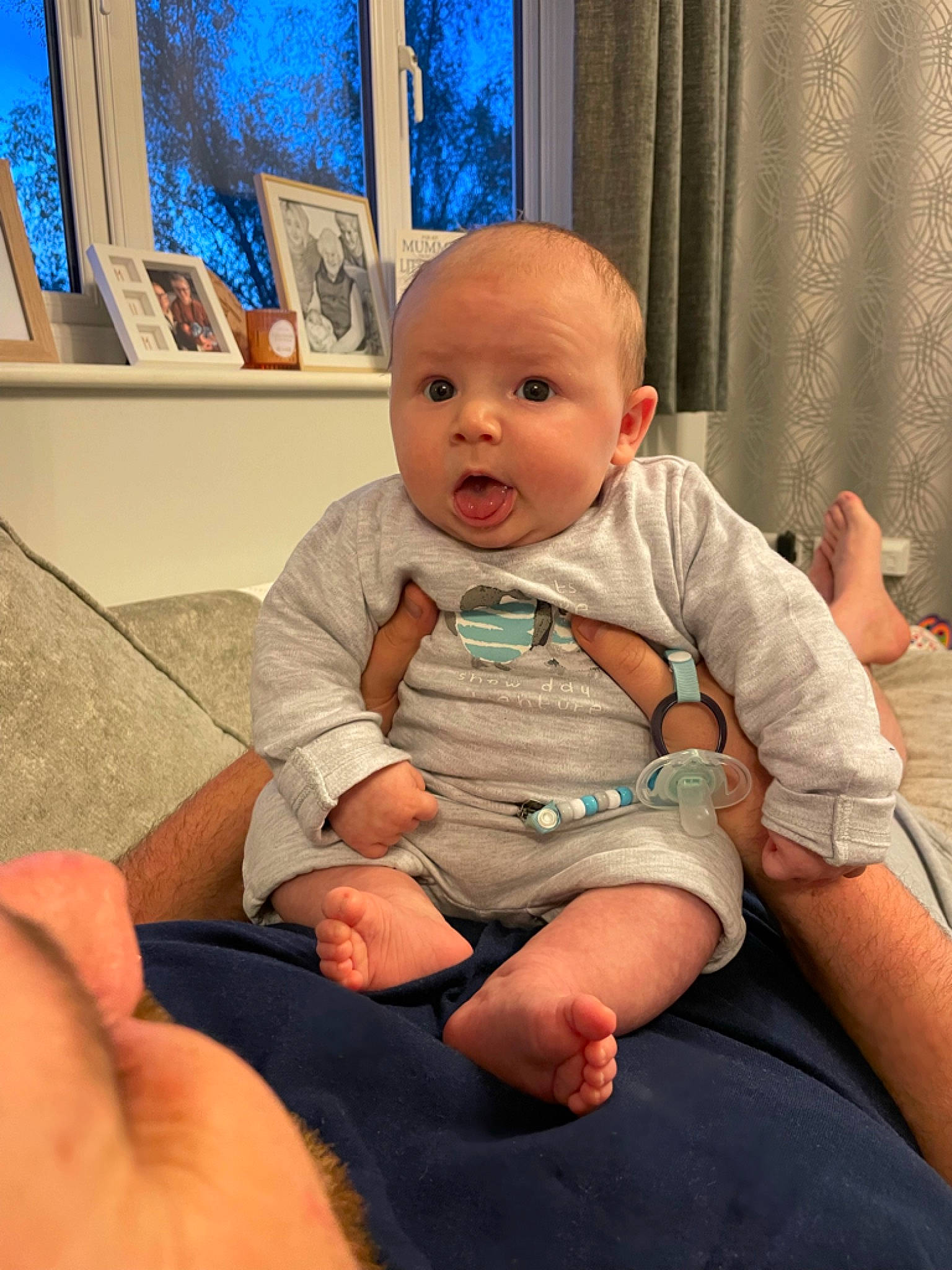 Barney is registered to the contest to win money with this photo: baby, baby_toddler_clothing, blue, cheek, child, chin, comfort, elbow, eye, finger, flooring, joint, knee, lap, mouth, person, shoulder, skin, standing, surprise