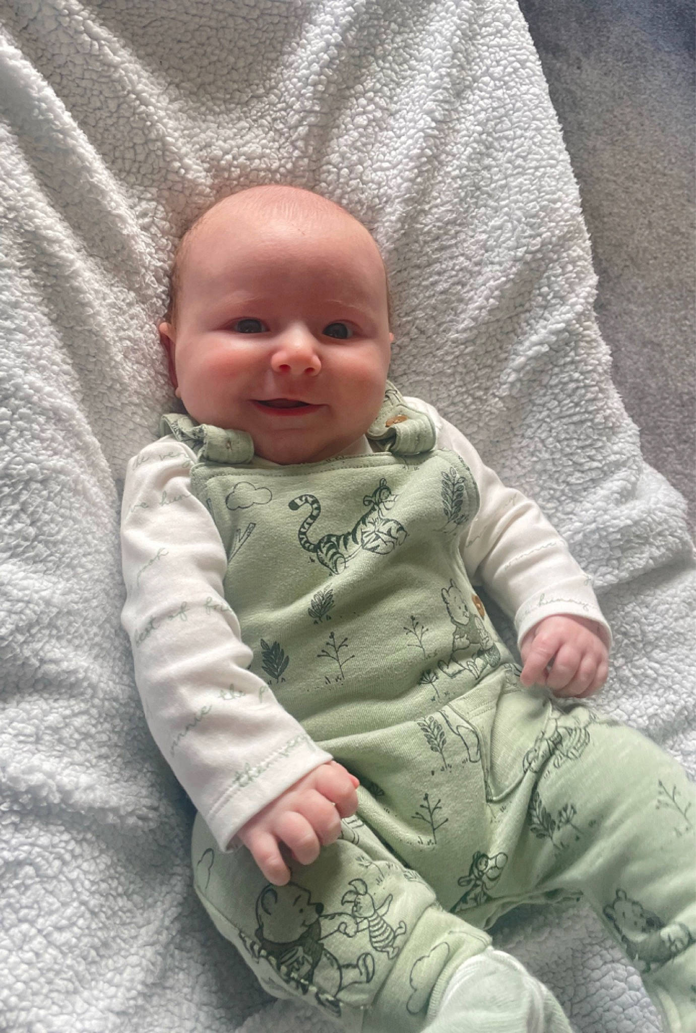 Barney is registered to the contest to win money with this photo: baby, baby_products, baby_toddler_clothing, cheek, child, comfort, face, gesture, grass, head, linens, pattern, person, product, sitting, skin, sleeve, smile, textile, toddler
