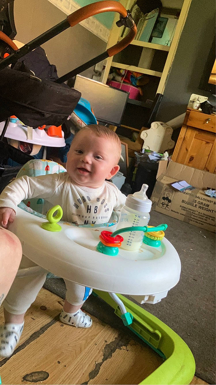 Harlow-george is registered to the contest to win money with this photo: baby, baby_products, baby_safety, baby_toddler_clothing, box, cabinetry, chair, child, drawer, flooring, fun, happy, person, product, room, sandal, shipping_box, sitting, smile, t_shirt