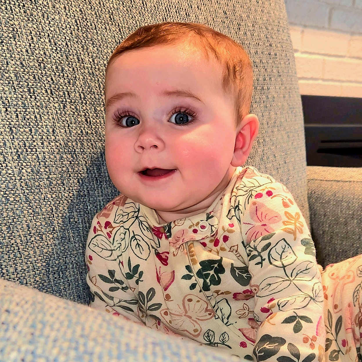 Rosie is registered to the contest to win money with this photo: baby, blanket, blonde, chair, clothing, couch, cushion, face, furniture, hair, happy, head, homedecor, pants, person, photography, portrait, quilt, sitting, smile