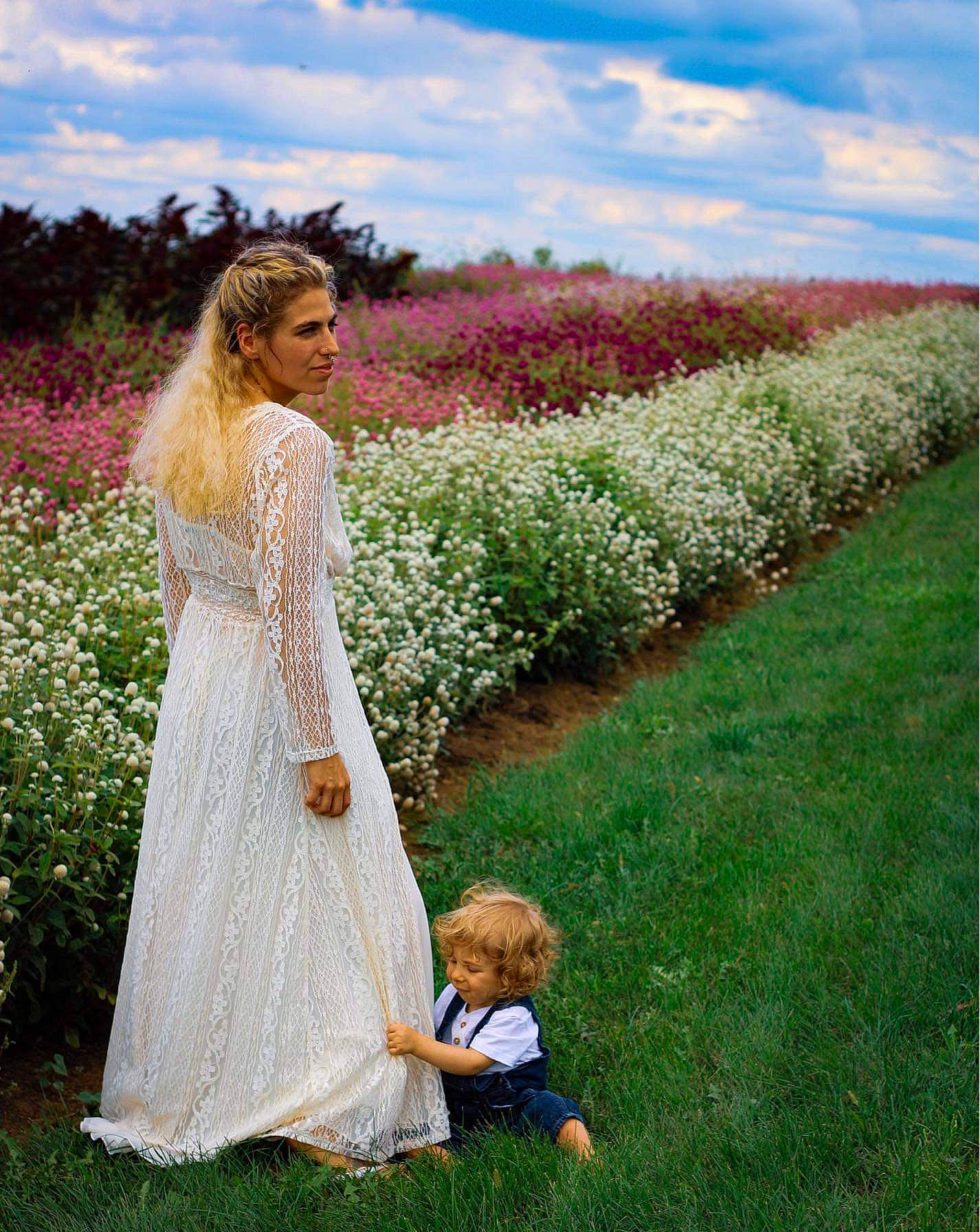 Mycah is registered to the contest to win money with this photo: bridal_party_dress, bride, cloud, dress, flower, formal_wear, grass, grass_family, grassland, happy, landscape, lawn, meadow, people_in_nature, person, petal, plant, sky, toddler, tree