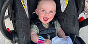 William joined the competition — help win amazing prizes! baby, car_seat, britax, smiling, blue_eyes, wrist_rattle, blanket, infant, safety_harness, outdoor, concrete, happy, cute, child, person, foot, hand, clothing, toy, seat