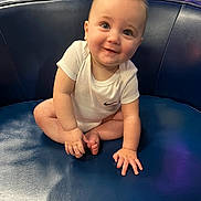 Jackson joined the competition — help win amazing prizes! baby, infant, child, onesie, smile, blue_chair, indoor, cute, happy, sitting, person, skin, face, hand, foot, short_hair, young, leather, clothing, portrait