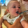 Jackson joined the competition — help win amazing prizes! baby, child, feeding, spoon, food, blue_food, mouth, hand, arm, person, indoor, shirt, curious, messy, holding, closeup, face, infant, dinosaur_print, adult