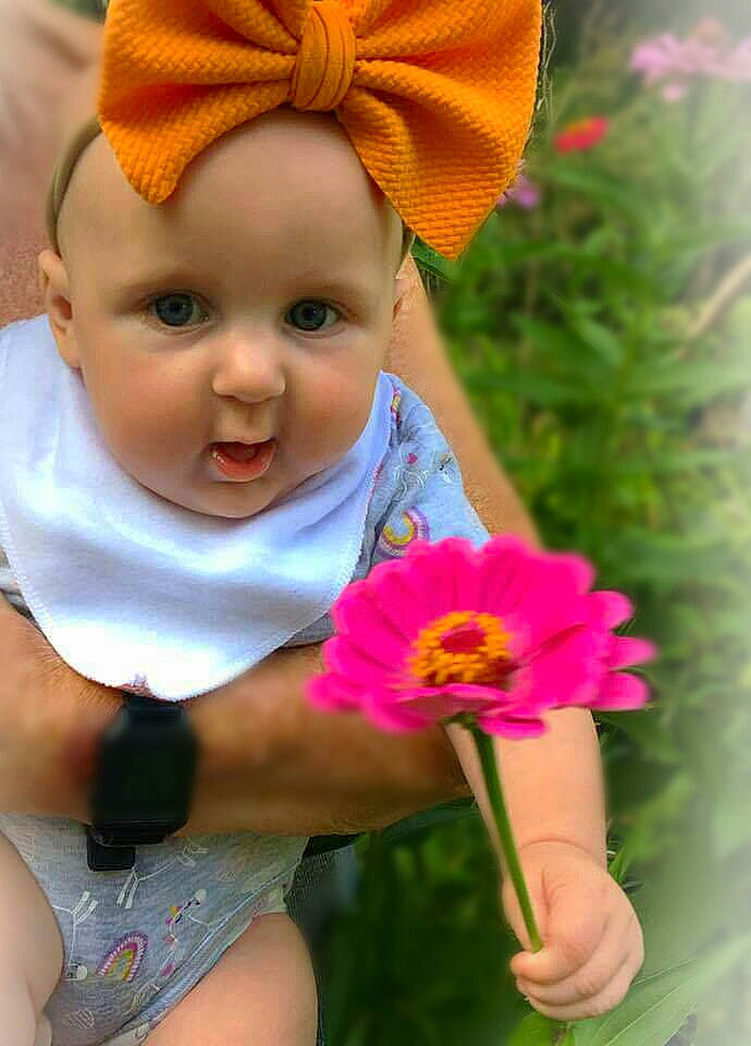 Pyper is registered to the contest to win money with this photo: baby, baby_products, baby_toddler_clothing, cheek, child, flower, hair_accessory, head, headband, headgear, headwear, person, petal, pink, plant, skin, toddler, wildflower, yellow