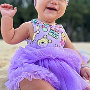 Bella Marie joined the competition — help win amazing prizes! baby, child, smiling, purple_tutu, headband, sand, outdoor, happy, cute, portrait, sitting, waving, nature, playful, infant, clothing, headwear, skin, face, sunlight