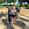 baby, blanket, chain, child, daylight, foot, grass, happy, nature, outdoor, park, pavilion, person, playground, sand, shadow, smiling, sunlight, swing, trees