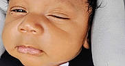 Raiden is registered to the contest to win money with this photo: baby, car_seat, child, closeup, clothing, expression, face, harness, head, indoors, infant, newborn, one_eye_closed, padded_cushion, person, safety, seatbelt, skin, transport, white_shirt