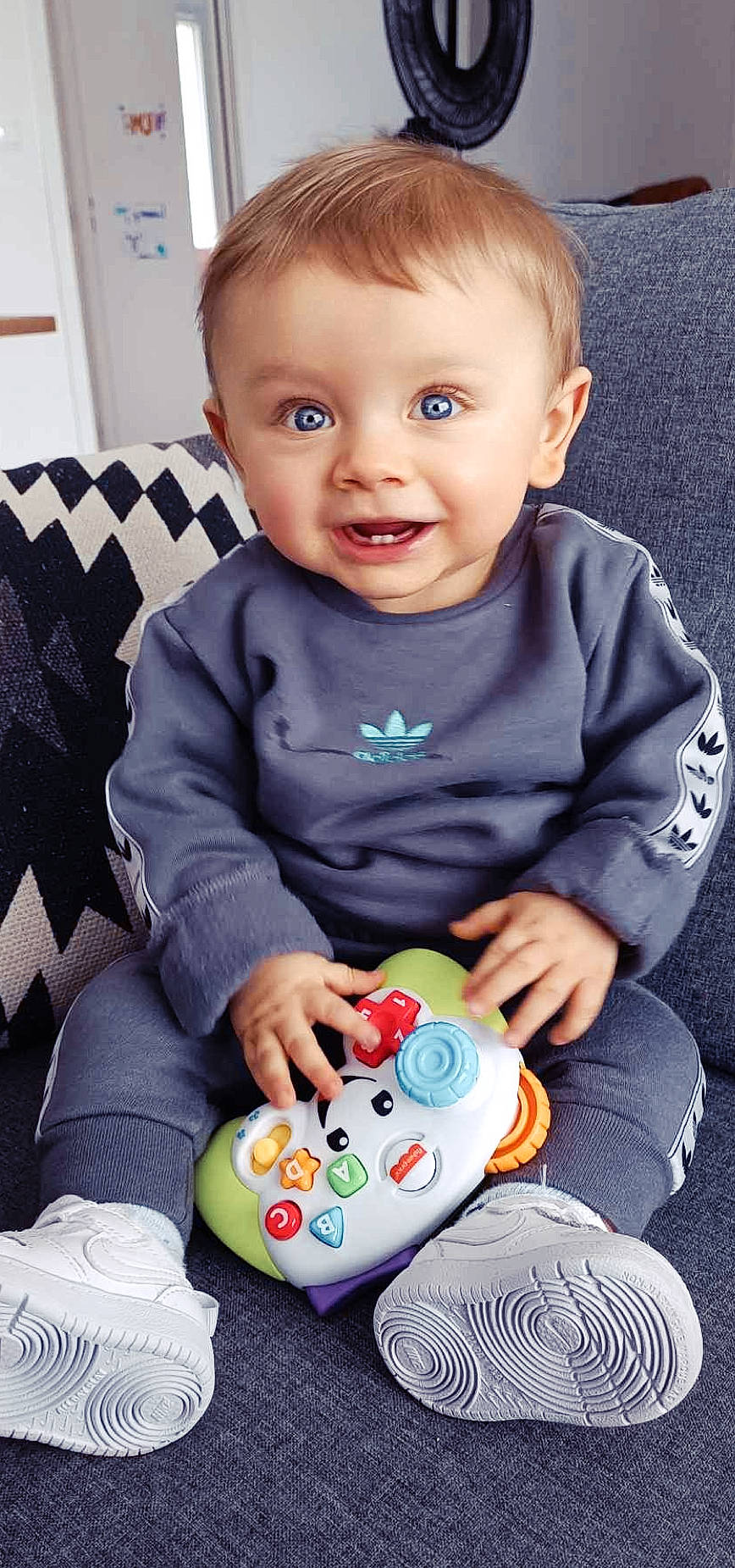 Leyann participe au concours pour gagner de l'argent avec cette photo : baby, baby_playing_with_toys, baby_toddler_clothing, blue, cheek, child, facial_expression, fun, gadget, happy, iris, joy, lap, people, person, product, skin, sleeve, smile, toddler