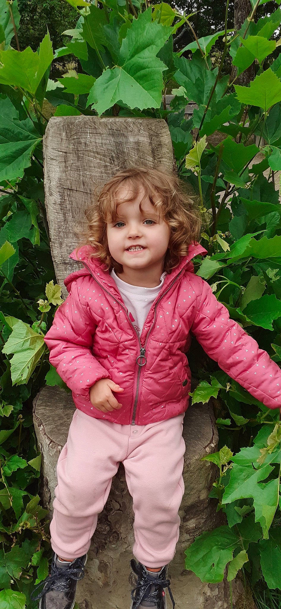 Lea participe au concours pour gagner de l'argent avec cette photo : baby_toddler_clothing, botany, cheek, child, gesture, grass, green, happy, jacket, leaf, outerwear, people_in_nature, person, pink, plant, sleeve, smile, spring, thumb, toddler