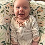 Eliza is registered to the contest to win money with this photo: baby, smiling, onesie, infant, floral, cushion, happy, face, child, cute, pattern, clothing, portrait, sitting, indoors, young, skin, hand, comfort, cozy