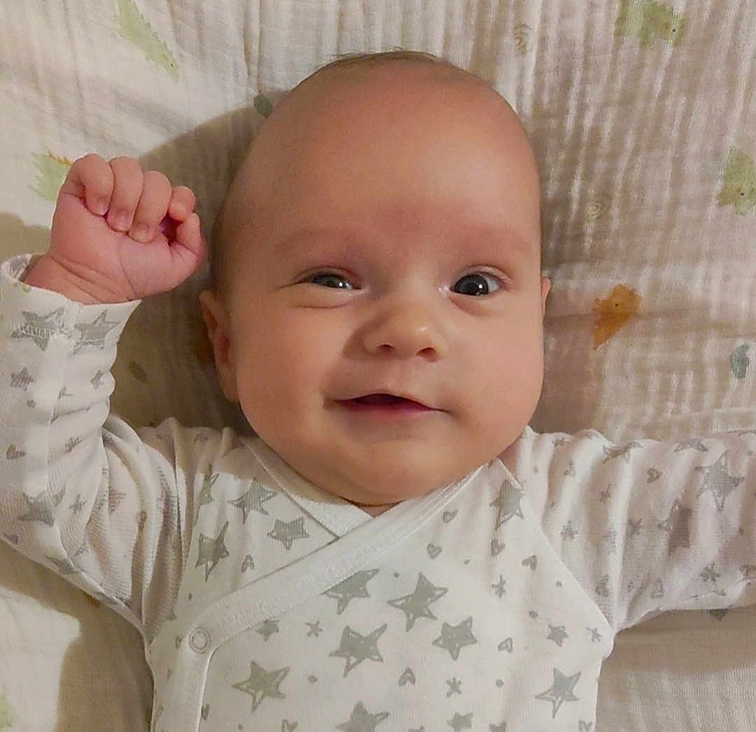 Isaïah a rejoint le concours — aidez-le/la à gagner de superbes lots ! baby, infant, smile, face, arm, blanket, stars, clothing, onesie, cute, happy, lying_down, skin, head, expression, child, newborn, person, indoors, closeup