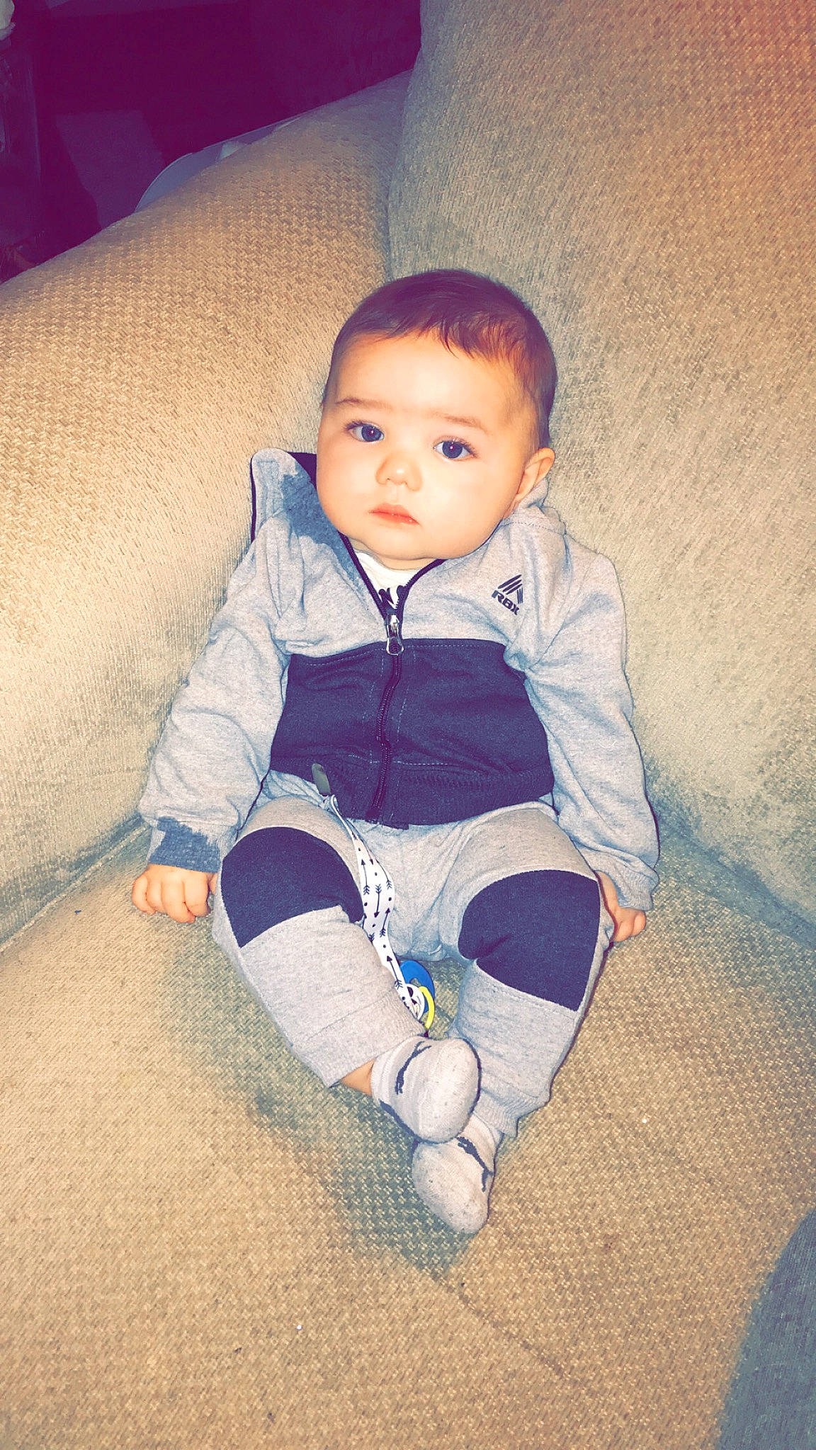 Jase is registered to the contest to win money with this photo: baby, baby_toddler_clothing, cheek, child, comfort, electric_blue, flash_photography, flooring, happy, human_body, human_leg, nose, pattern, person, sitting, skin, sleeve, sock, t_shirt, tints_and_shades