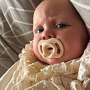 Willow is registered to the contest to win money with this photo: baby, pacifier, face, infant, lace, clothing, blanket, cushion, pattern, closeup, portrait, soft, texture, indoor, child, cute, expression, newborn, resting, cozy