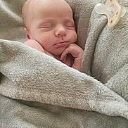 Star is registered to the contest to win money with this photo: newborn, baby, sleeping, blanket, pacifier, soft_texture, cozy, peaceful, infant, wrapped, hand, face, resting, closeup, indoors, comfort, toddler, skin, cute, nap