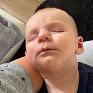 Menzo participe au concours pour gagner de l'argent avec cette photo : baby, sleeping, child, face, closed_eyes, skin, person, couch, blanket, arm, clothing, comfort, peaceful, indoors, head, nap, rest, young, closeup, relaxation