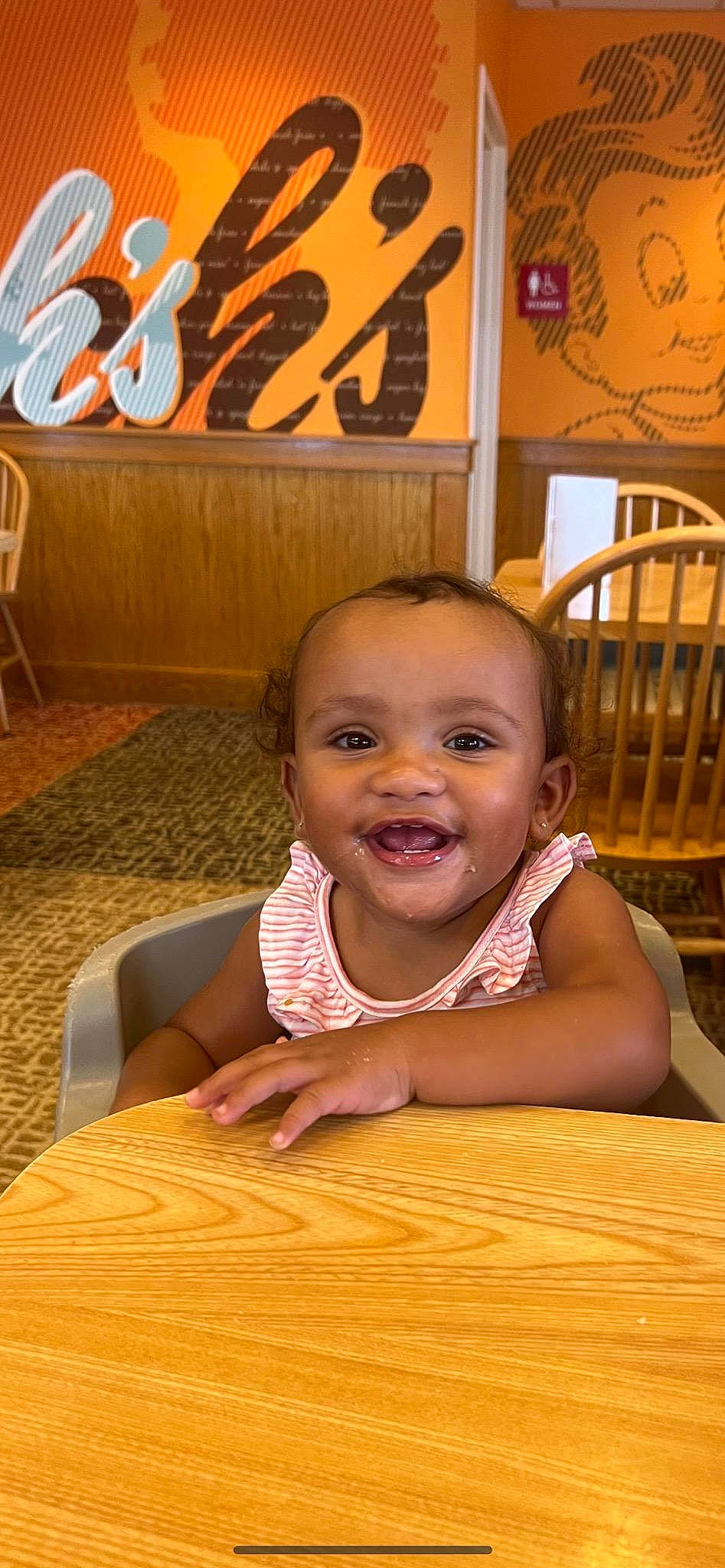 Brooklynn is registered to the contest to win money with this photo: baby, baby_toddler_clothing, chair, cheek, child, chin, flooring, fun, happy, hardwood, joy, leisure, mouth, nose, organ, person, sitting, skin, smile, table
