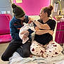 Teddy Keith is registered to the contest to win money with this photo: newborn, baby, man, woman, hospital, bed, blanket, pajamas, tattoo, beanie, sitting, medical_equipment, love, family, parent, indoor, phone, comfort, care, pink_wall