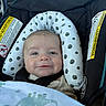 baby, car_seat, blanket, dinosaur, headrest, infant, smile, child, seatbelt, polka_dot, cute, face, indoors, safety, happy, clothing, portrait, infant_care, transportation, comfort