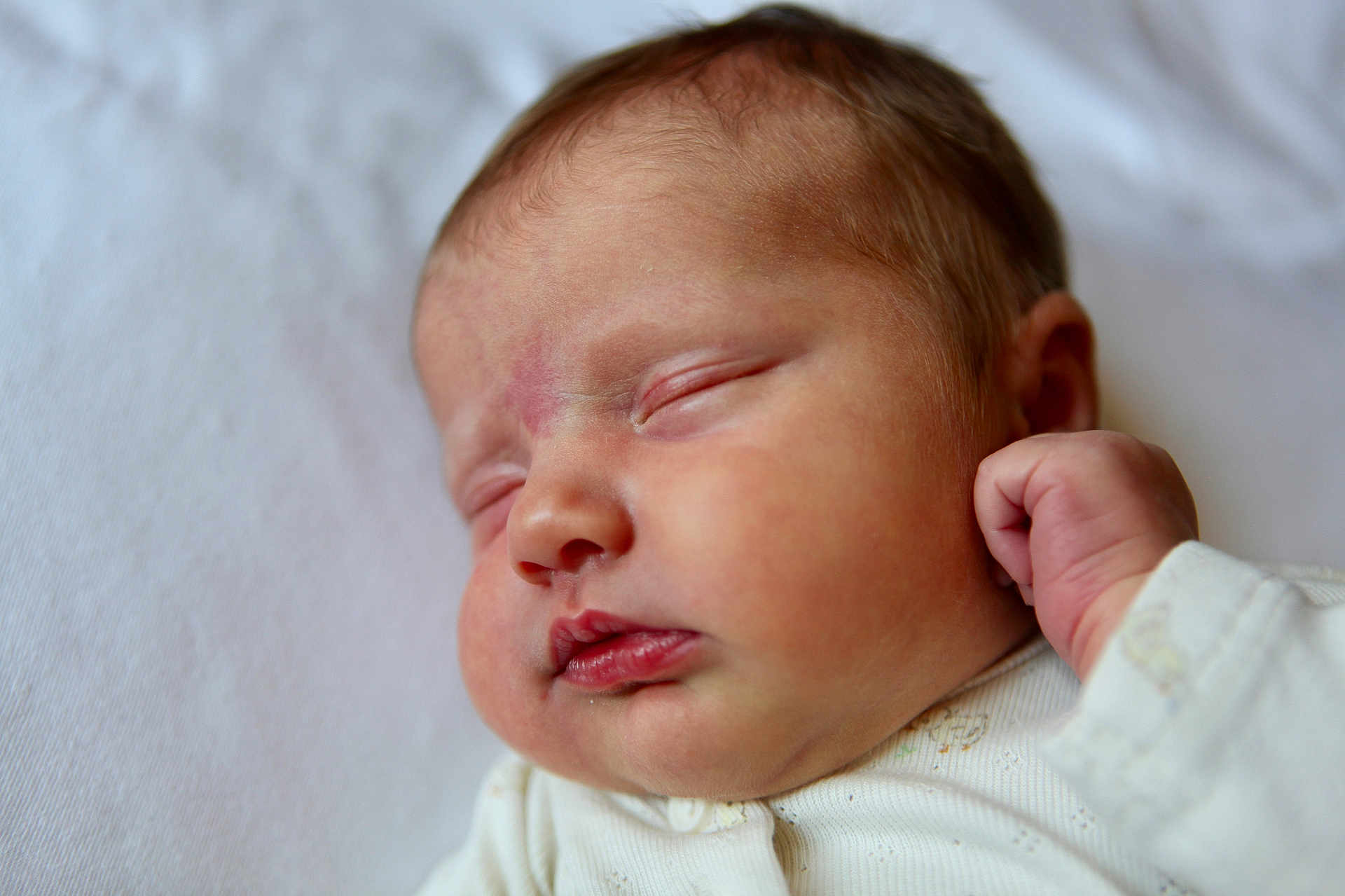 Sunny is registered to the contest to win money with this photo: baby, newborn, sleeping, close_up, face, infant, skin, peaceful, fist, cute, soft, white_background, clothing, portrait, child, resting, peace, small, fresh, newborn_baby