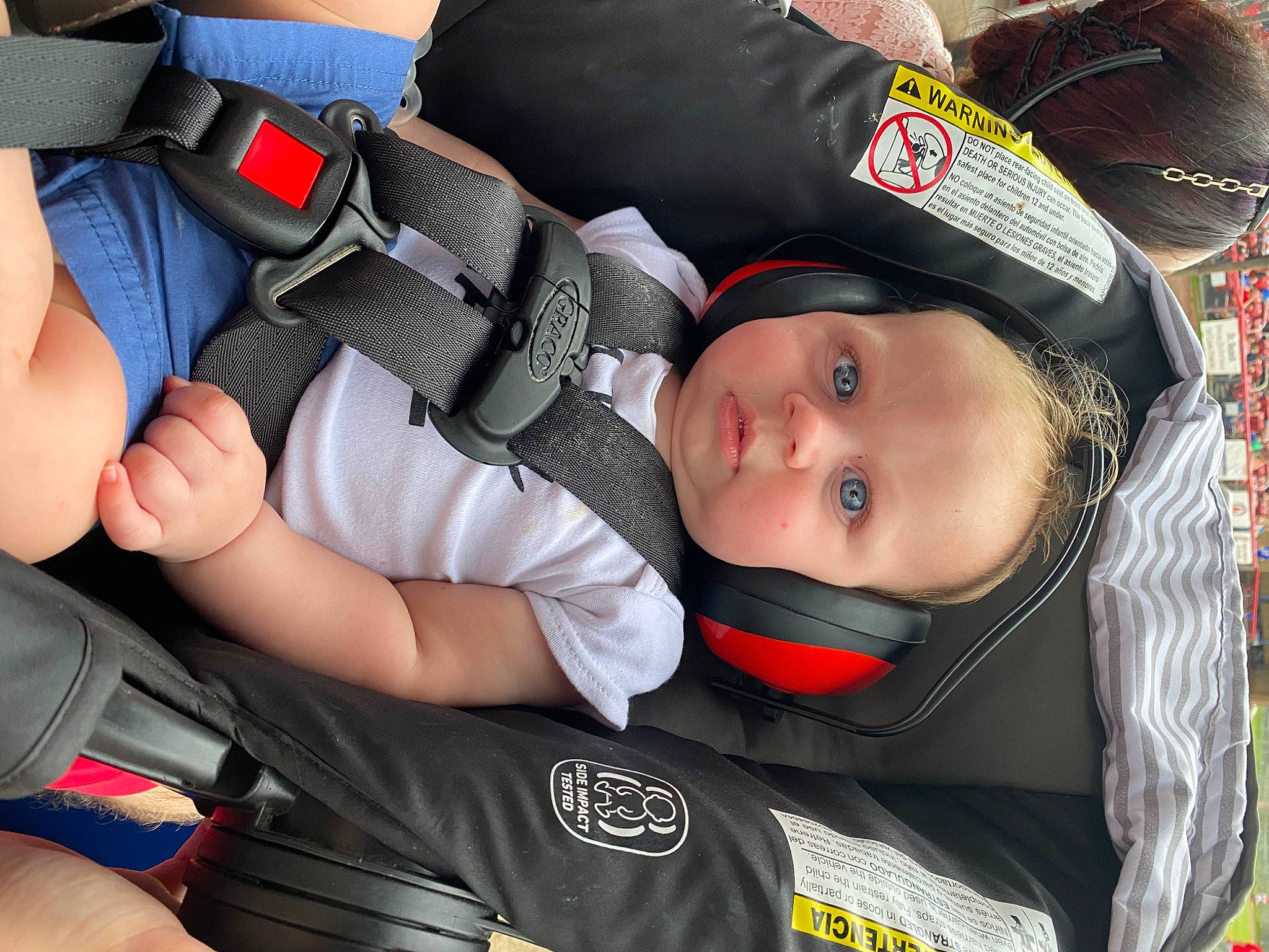 Ethan is registered to the contest to win money with this photo: auto_part, baby, baby_carriage, baby_products, baby_toddler_clothing, car_seat, carmine, child, comfort, elbow, hat, person, personal_protective_equipment, smile, toddler