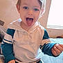 Austin is registered to the contest to win money with this photo: child, toddler, indoor, bed, blanket, window, light, tongue_out, playful, hoodie, blue_eyes, hair, sitting, cute, smiling, person, young_child, casual_clothing, hand, expression