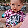 blue_eyes, casual_clothing, child, curious, daylight, expression, face, garden, hand, holding, leaf, nature, outdoor, person, portrait, shirt, short_hair, tie_dye, toddler, young