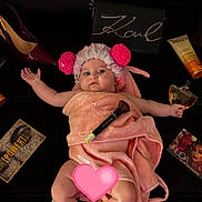 Azura participe au concours pour gagner de l'argent avec cette photo : baby, beauty_products, black_background, child, cosmetics, cute, face, fluffy_hat, hat, high_heel_shoe, indoor, lying_down, makeup_brush, perfume_bottle, person, pink, pom_poms, relaxing, skin, towel