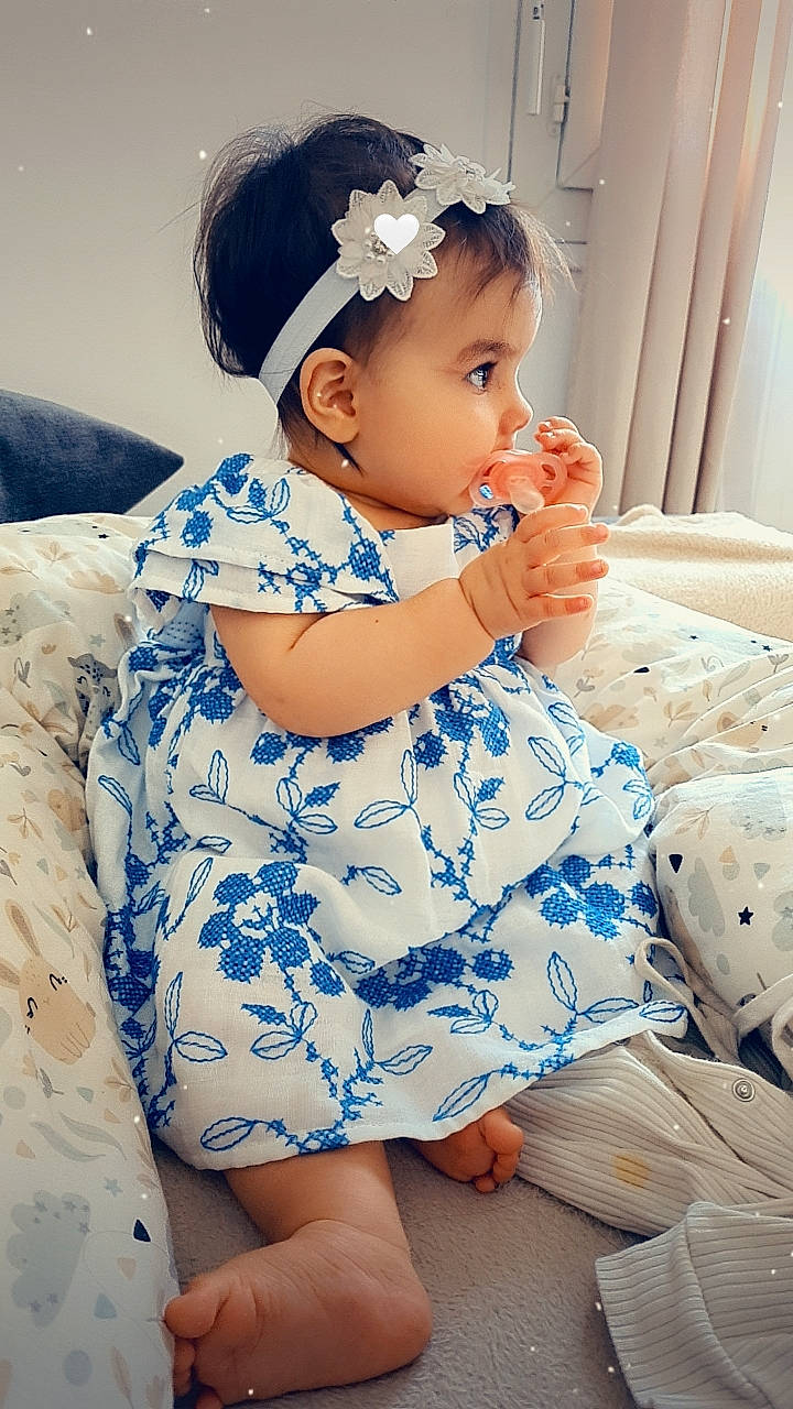 Luisa participe au concours pour gagner de l'argent avec cette photo : azure, baby, baby_toddler_clothing, black_hair, comfort, dress, eye, facial_expression, flash_photography, hair, happy, hat, head, human, neck, person, skin, sleeve, textile, thigh