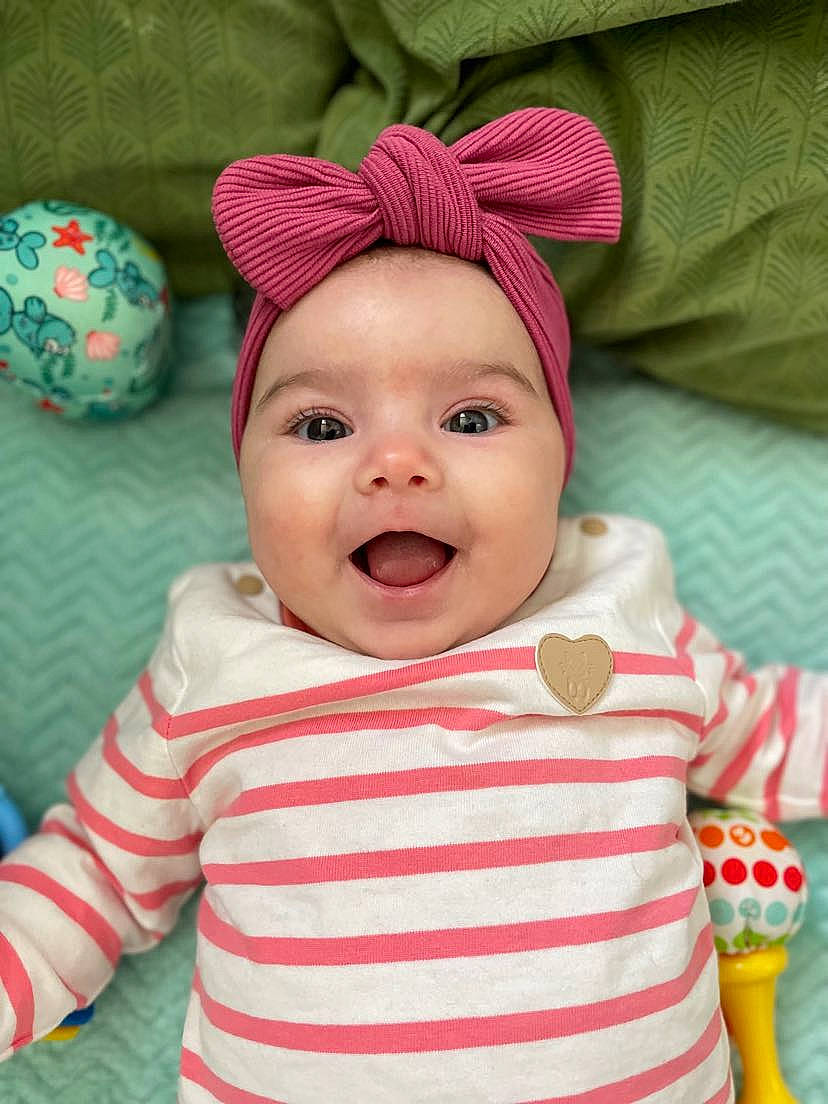 Luisa participe au concours pour gagner de l'argent avec cette photo : baby, baby_laughing, baby_toddler_clothing, cap, cheek, child, chin, face, fun, happy, headgear, headwear, lip, nose, person, pink, skin, sleeve, smile, textile